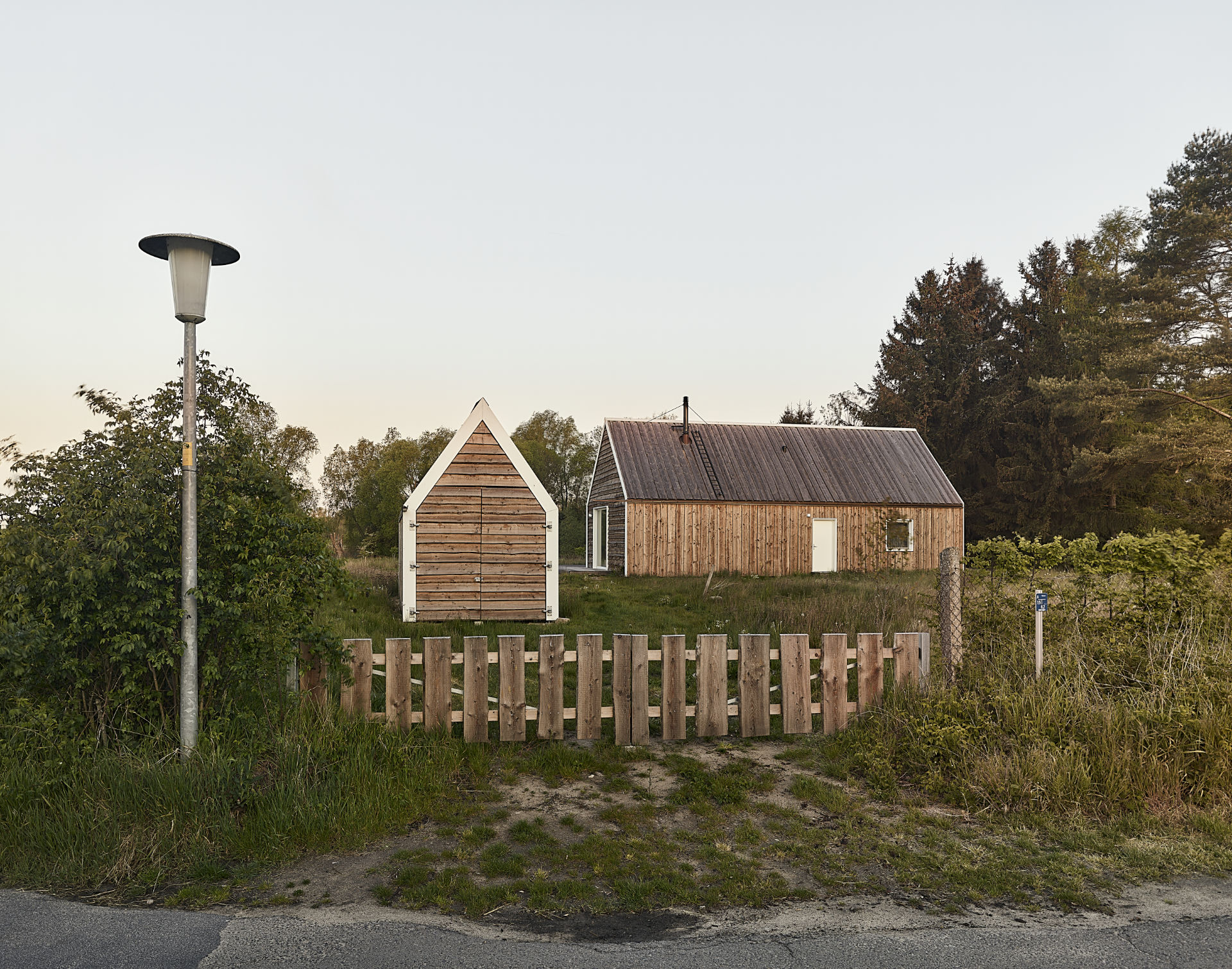 Zaunpforte zu Wildblumenwiese mit Ferienhaus