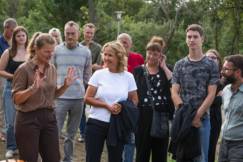 Besuchergruppe und Bundesumweltministerin lauschen Vortrag von Claudia Siebeck in Obstgarten