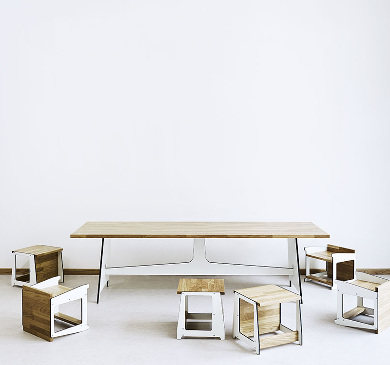Tisch mit Massivholzplatte und HPL-Gestell und lose umstehende Kinderhocker